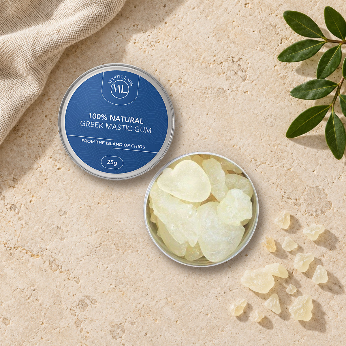 Pure Chios Greek mastic gum in a 25g aluminium tin, shown closed beside an open tin of natural mastic tears on pale stone